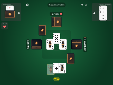 Euchre on an iPad held sideways: the score for each team in the top corners, the three other players' face-down hands around the green felt, a trick being played over Taco printed faintly in the middle with each team's won tricks on a corner, and the player's cards along the bottom.